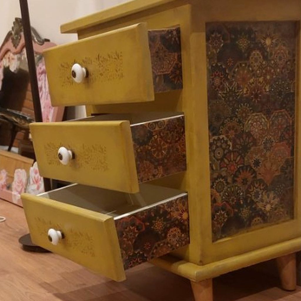 Mesilla amarilla con los tres cajones abiertos, se ve el decoupage también en los laterales de los mismos