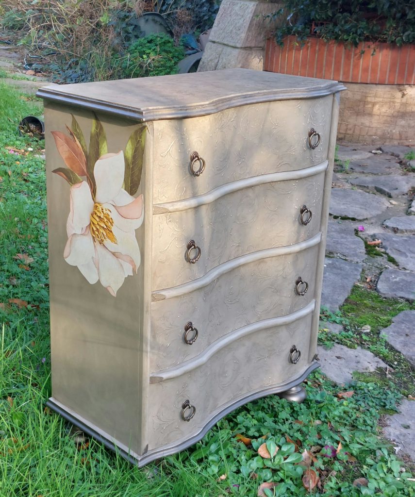 Mueble de cuatro cajones pintado y con una flor en la transferencia lateral