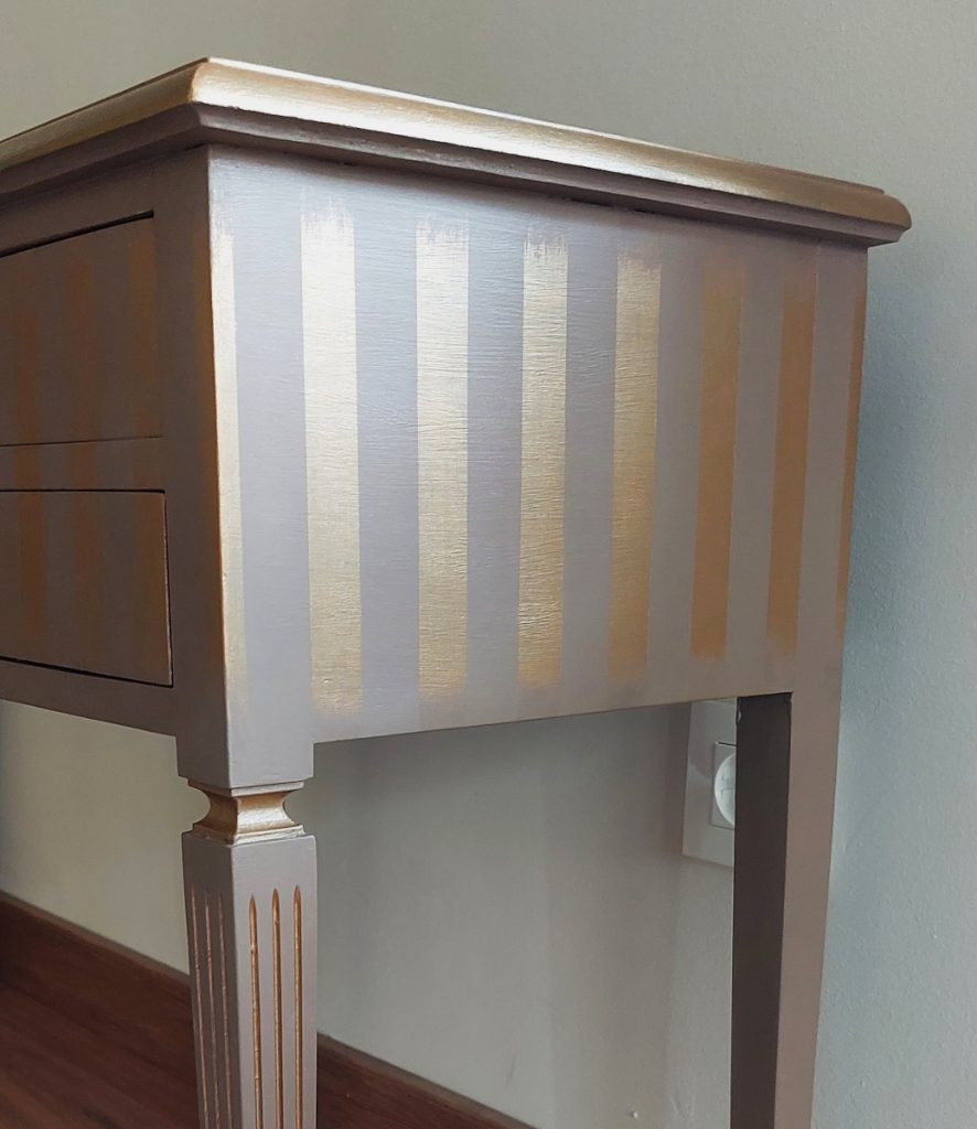 Detalle de las rayas doradas en el lateral de la mesilla