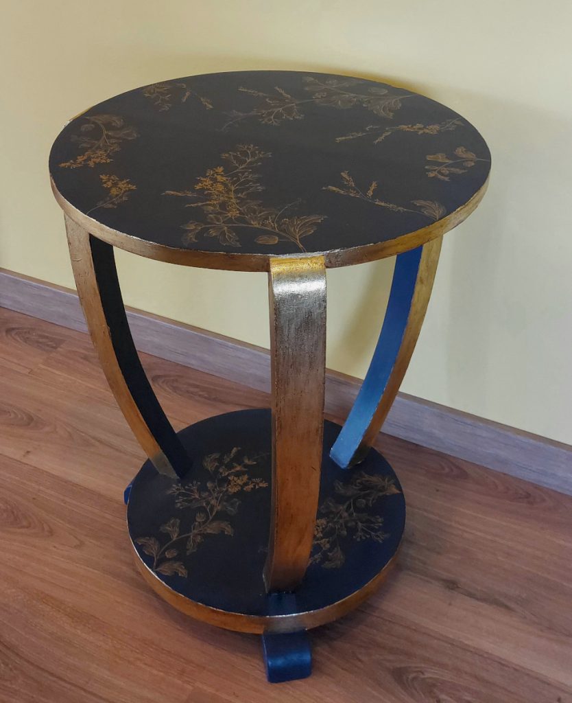 Mesita alta pintada en azul oscuro y con aplicaciones en dorado