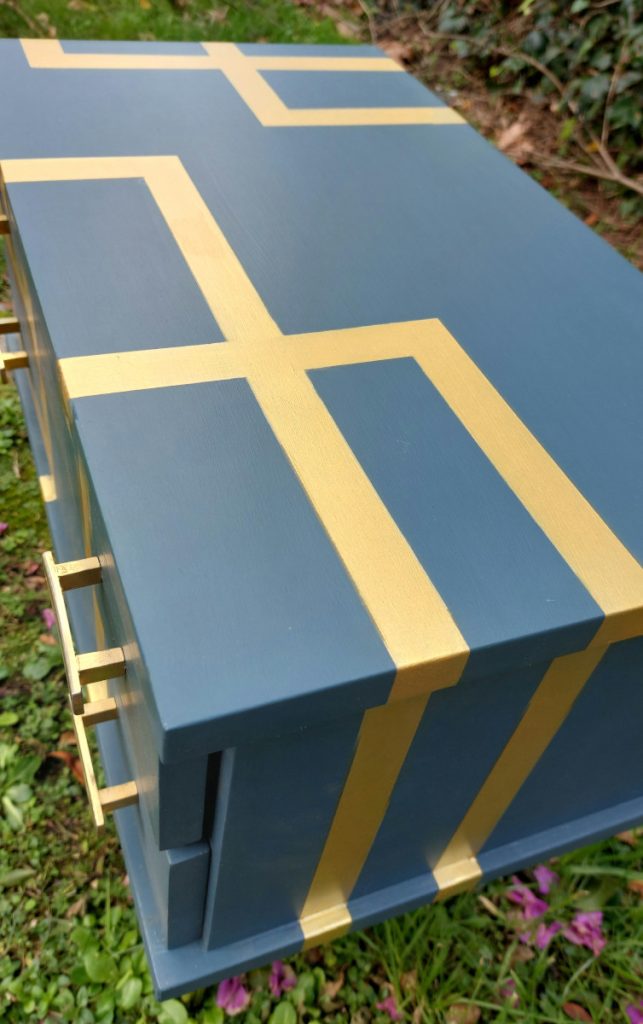 Mesilla que está pintada de azul con líneas doradas atravesándolo.