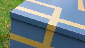 Mesilla que está pintada de azul con líneas doradas atravesándolo.