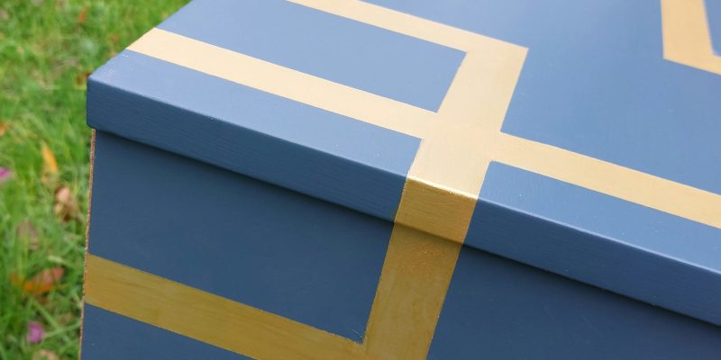 Mesilla que está pintada de azul con líneas doradas atravesándolo.