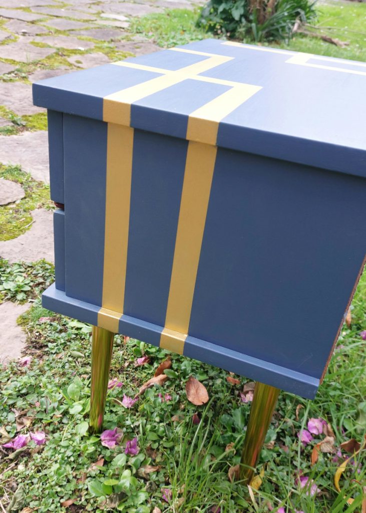 Lateral de la mesilla azul y con líneas doradas