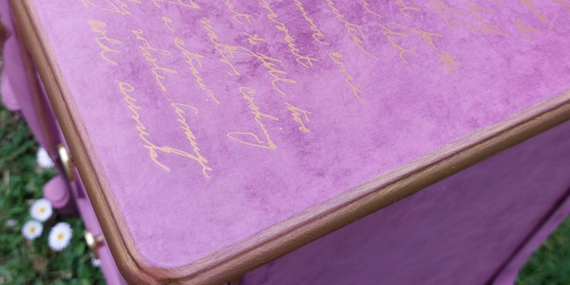 Parte superior de la mesita con una transferencia de letras doradas