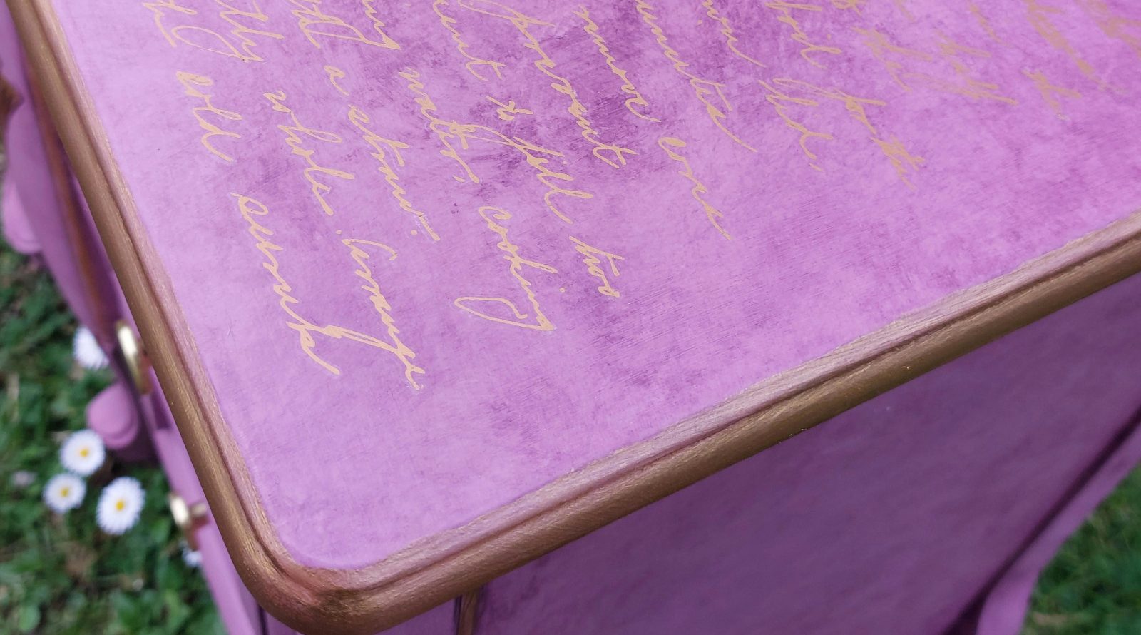 Parte superior de la mesita con una transferencia de letras doradas